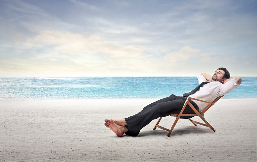 A businessman is relaxing at the beach
