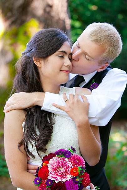 istock Caucasian groom lovingly kissing bride on cheek. 527170269