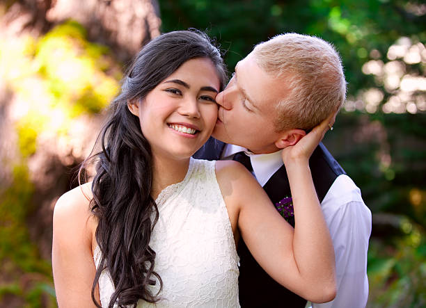 istock Caucasian groom lovingly kissing his bride on cheek. 527170299