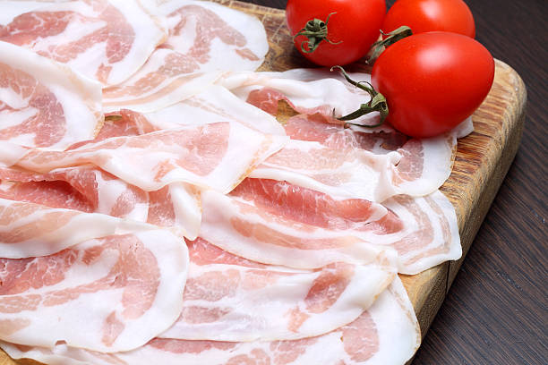 istock Bacon slices with tomatoes on wooden cutting board 527173491