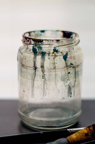istock An artist's water jar with paint drips with brushes 527214818