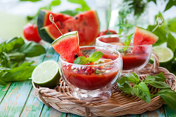 Watermelon Tomato Gazpacho Watermelon tomato gazpacho in glass bowls lime basil plant stock pictures, royalty-free photos & images