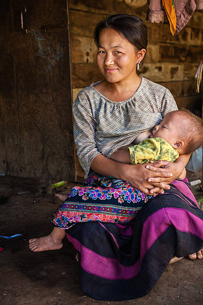 giovane donna nella tribù di collina in fase di allattamento al seno il suo bambino - sucking asian ethnicity baby mother foto e immagini stock