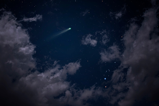 Comet visible among clouds.