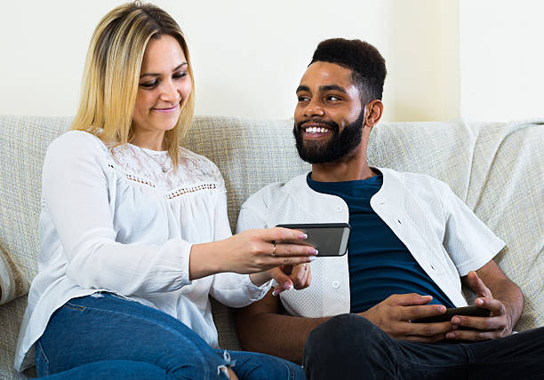 istock man and woman sitting on sofa 527218828