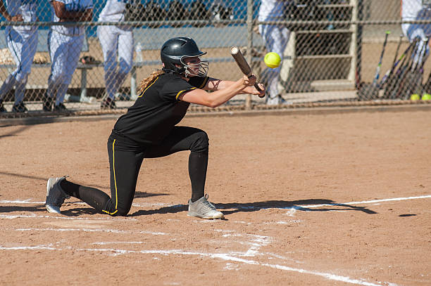 Athlete focused on contact point Fast high school softball player bunting the ball. bunt stock pictures, royalty-free photos & images