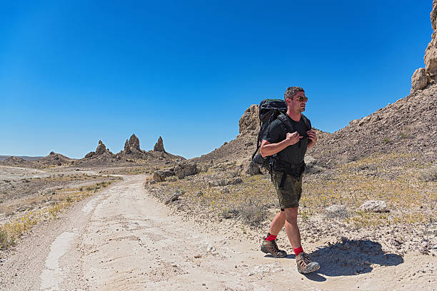istock Man Hiking Along a Desert Dirt Road 527220366