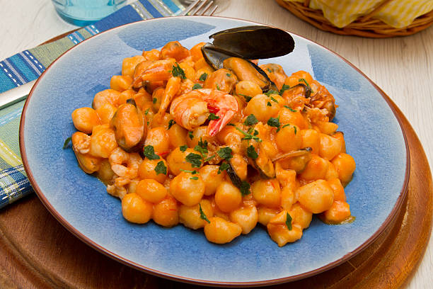 istock blue dish with gnocchi ,seafood and tomatoes sauce 527220618