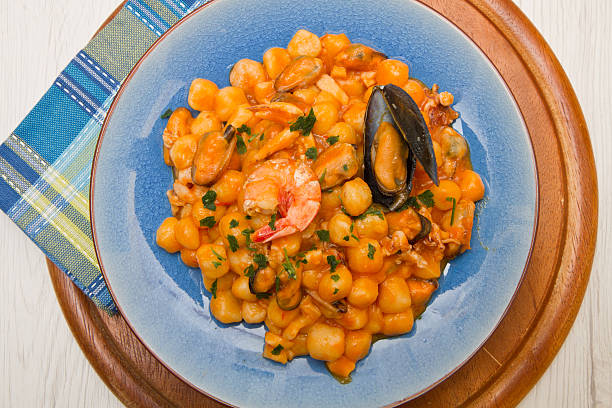 istock blue dish with gnocchi ,seafood and tomatoes sauce 527220936