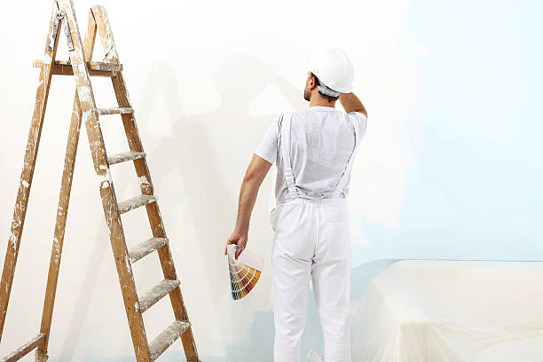 istock painter man at work with color swatches, wall painting 527222554