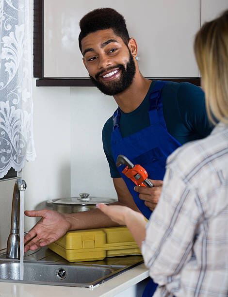 istock plumber and housewife in kitchen 527222694