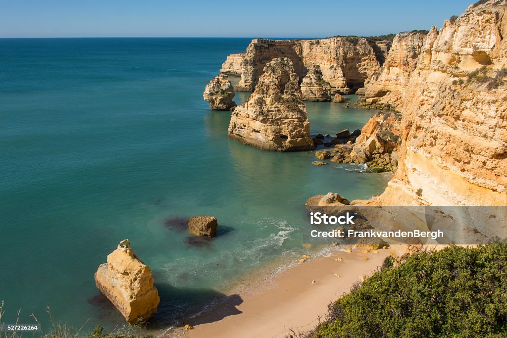 Navy Beach Golden sunlight over the coastline with the famous eroded rock formations at the Praia da Marinha, in the Algarve region of Portugal. Carvoeiro Stock Photo