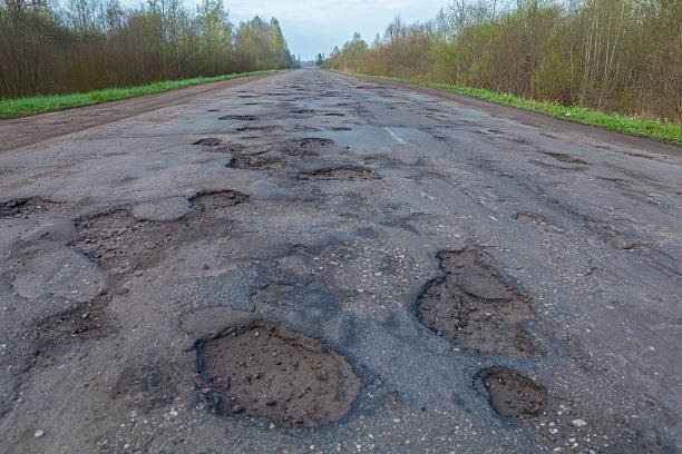 istock Large pits and holes on the asphalt's  road. 527227836
