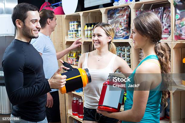 Group Of Young Adults Discussing Bodybuilding Supplements Stock Photo - Download Image Now