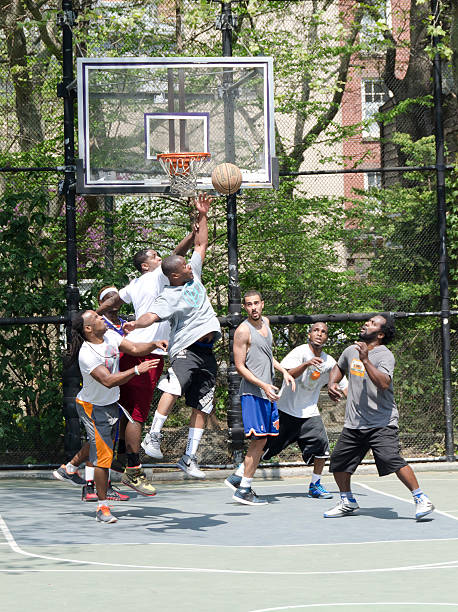 Hombres jóvenes en acción la actualidad jugando al básquetbol en la calle - foto de stock