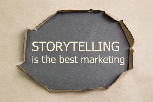 The motivational quote Storytelling is the best Marketing, appearing behind torn paper.