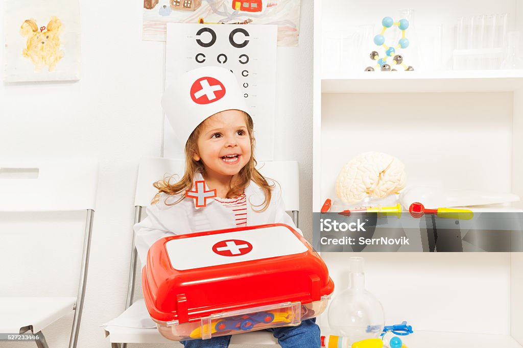 Mädchen gekleidet wie Arzt mit Spielzeug Erste-Hilfe-Brust - Lizenzfrei Verbandskasten Stock-Foto