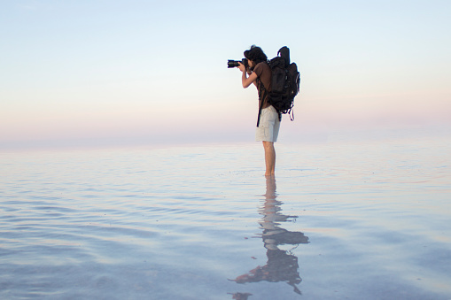 Photographer taking photo on the water. Image taken in Salt Lake in Aksaray, Turkey. Horizontal composition. Outdoor.