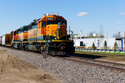 Fort Collins, Colorado, USA - May 13, 2014: A BNSF train in downtown Fort Collins with people in the background. Burlington Northern Santa Fe is a major railway operator and part of Warren Buffett's Berkshire Hathaway.