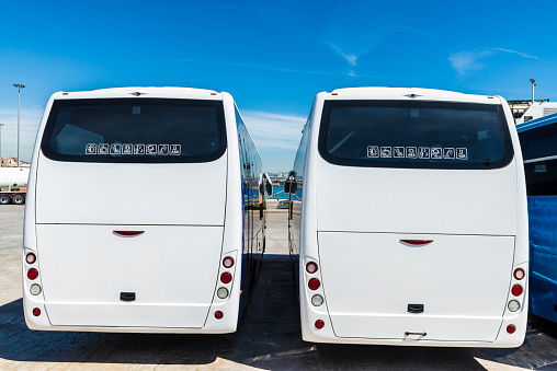 Two white buses parked at the port of Barcelona, Catalonia, Spain