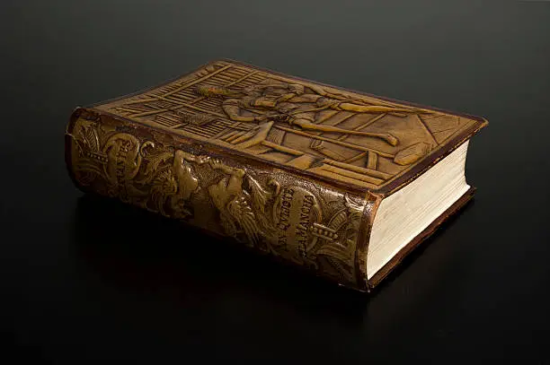 Miguel de Cervantes' Death Fourth Centenary. Old Embossed Leather Book Edition of The Ingenious Gentleman Don Quixote of La Mancha, Isolated on Dark Background