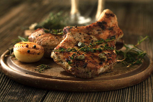 istock Grilled pork chop with spices, garlic and onions. 527236754