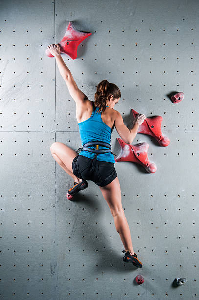 Young rock climber climbing on wall