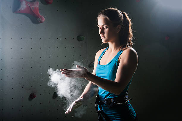 istock Climber woman coating her hands in powder chalk magnesium 527240028