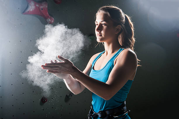 istock Climber woman coating her hands in powder chalk magnesium 527240132