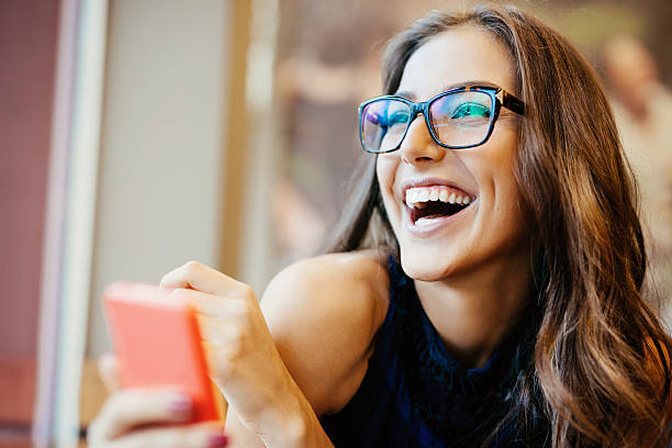 joven mujer enviando mensajes de texto en smartphone - cheerful happiness smiling teenager fotografías e imágenes de stock