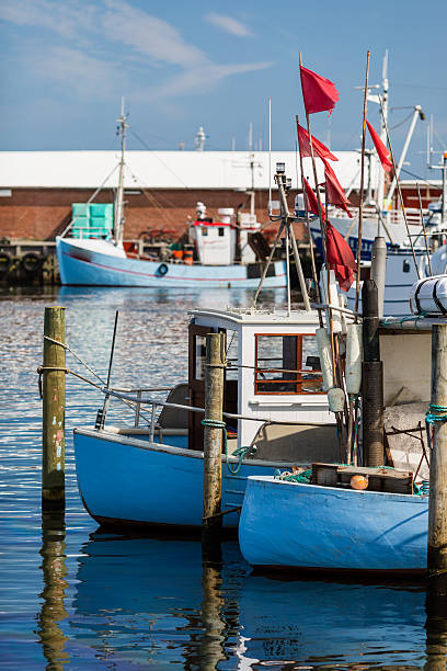 Two small fishing vessels mooring in the harbor on a sunny day.