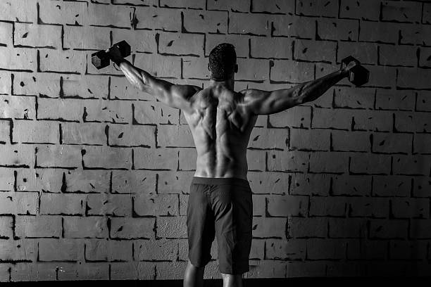 istock gym man rising hex dumbbells weightlifting rear 527274095