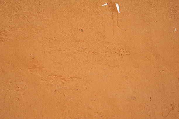 istock Texture of old wall covered with yellow stucco 527343635