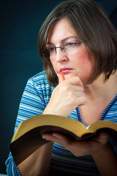 istock Adult Woman meditating while Reading the Bible 527345907