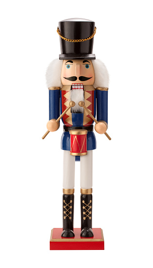 Antique Nutcracker Drummer with a red drum. He has white hair and beard. He sports a black hat, with a blue coat and black boots. The point of view is straight on, and is isolated on a white background.