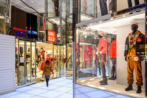 Tokyo, Japan - December 29, 2012: A shopper walks into a UNIQLO clothing store. The fashion retailer is headquartered in Tokyo with hundreds of store locations in over a dozen countries.