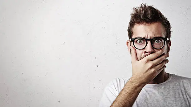 Portrait of a surprised young man wearing eyeglasses