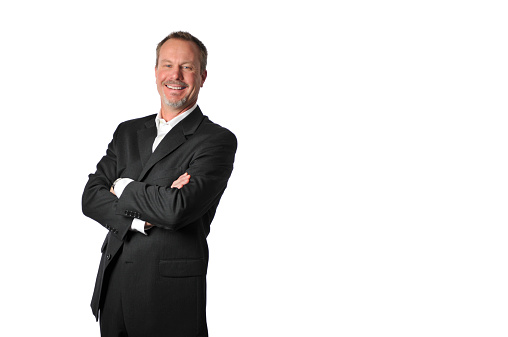 Horizontal image of an attractive middle aged man dressed in a nice suit. He has a very happy expression and his arms are crossed. This was photographed in the studio on a white background.