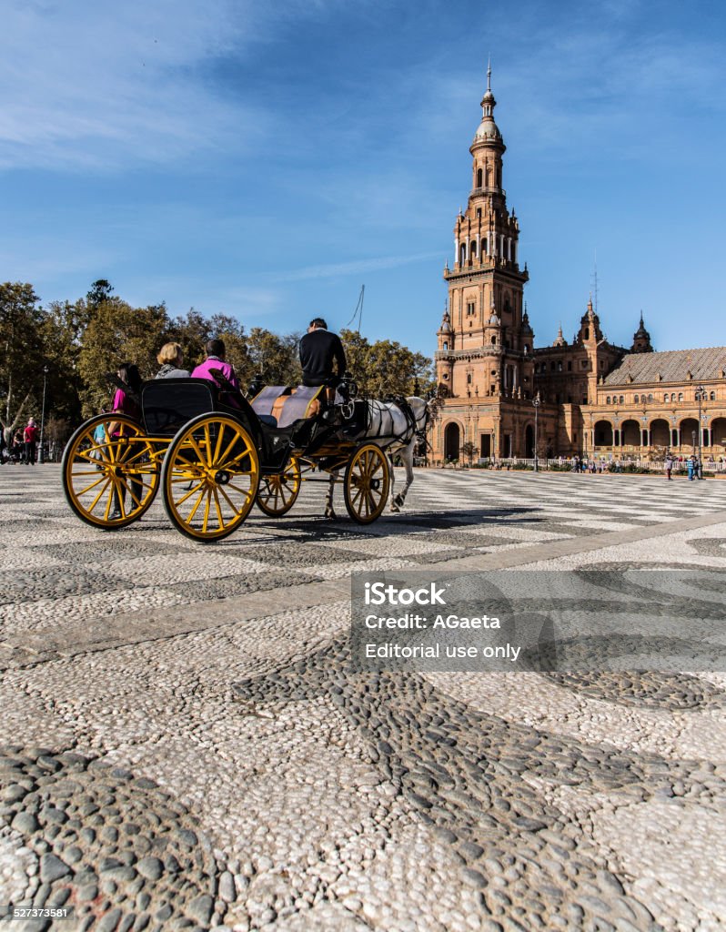 Seville, Spain, Spanish Steps Seville, Spain. November 15, 2014. A carriage with two tourists crossing Piazza di Spagna, a huge circular square popular with tourists and Spaniards  who come here to relax, read, take children on ponies and let them play in the park. Andalusia Stock Photo