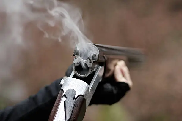 Closeup of a smoking traditional skeet shooting shotgun after shots fired