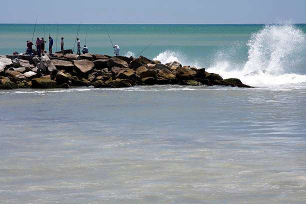 Mar del Plata City, Buenos Aires Province, Argentina - November 23, 2014: A group of fishermen on the breakwater. Atlantic Ocean.