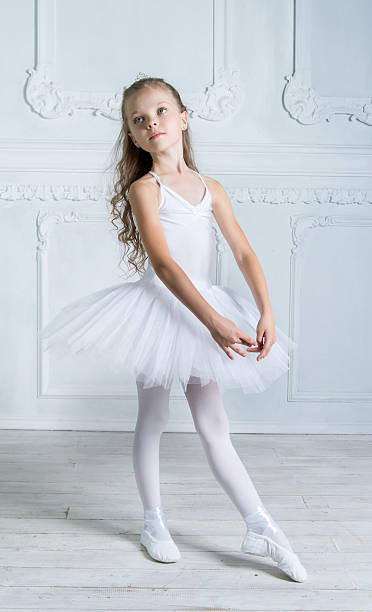 istock young ballerina in white tutu is posing in interior studio 527393771