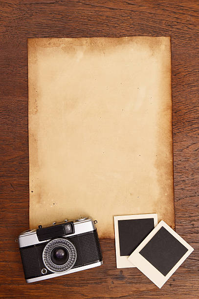 istock Old paper and vintage photo frame with camera 527396531