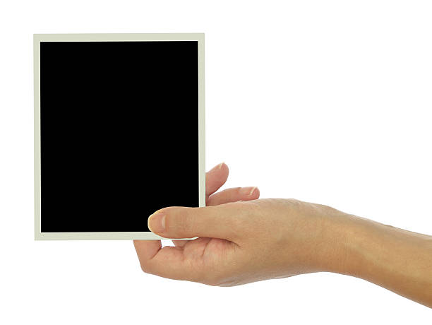 istock Hand holding blank photo frame isolated on white background 527398343