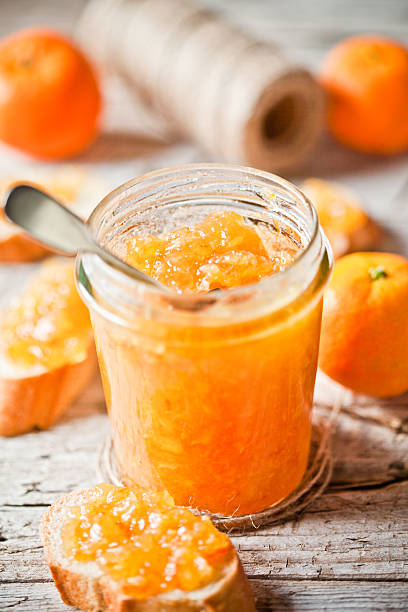 istock orange jam in glass jar, tangerines and bread 527437501