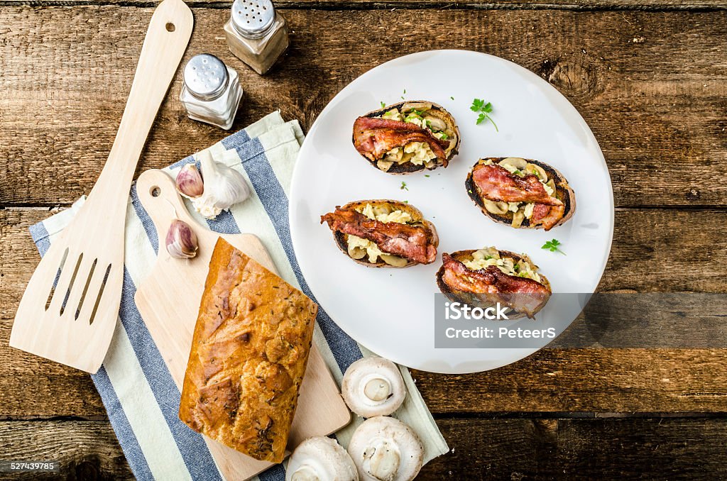 Rustic breakfast - bread toast, mushrooms, eggs Rustic breakfast - garlic toast, fried mushrooms, scrambled eggs and bacon on top Bread Stock Photo