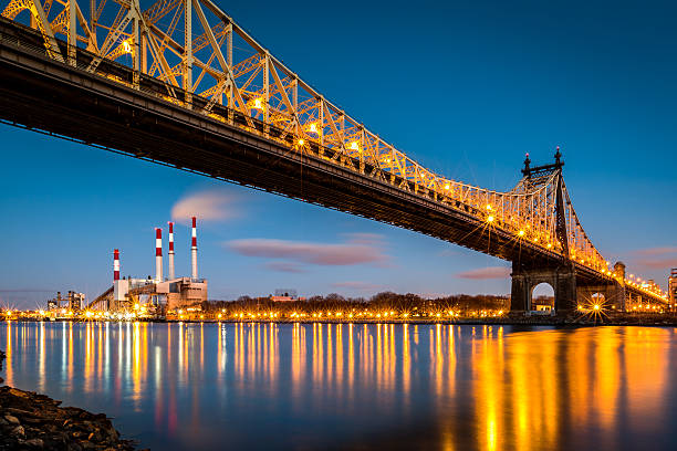 Queensboro bridge and Ravenswood station at dusk Ed Koch (aka Queensboro) bridge and the Ravenswood generating station as viewed from Roosevelt Island in New York roosevelt island stock pictures, royalty-free photos & images