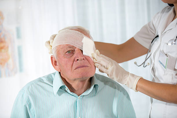 enfermera bandaging ojos a un hombre mayor envenenado - pain human eye senior adult men fotografías e imágenes de stock