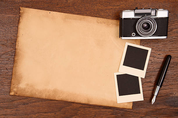 istock Old paper, ink pen and vintage photo frame with camera 527444271