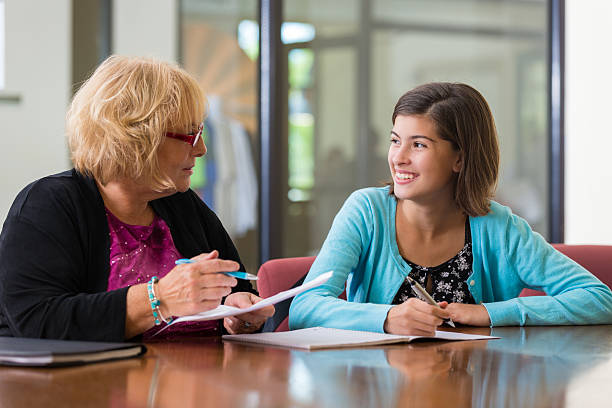 istock Teacher helping preteen student during after school tutoring program 527461671